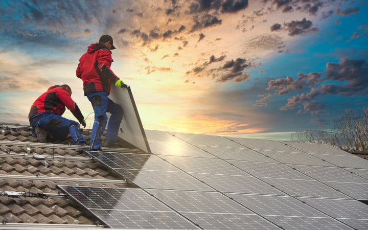 Installation de panneaux solaires sur une toiture en tuile par des artisans