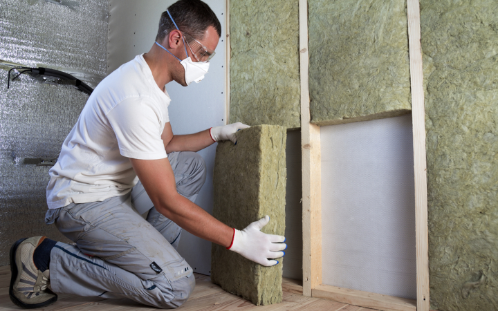 Artisan pose une isolation en fibre de bois par l'intérieur