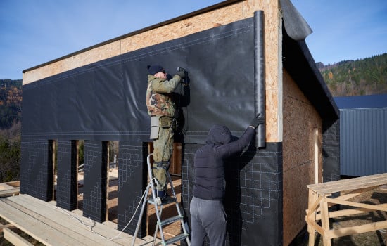 Pose d'un film isolation lors d'un chantier d'isolation par l'extérieure d'une maison par des artisans certifié RGE