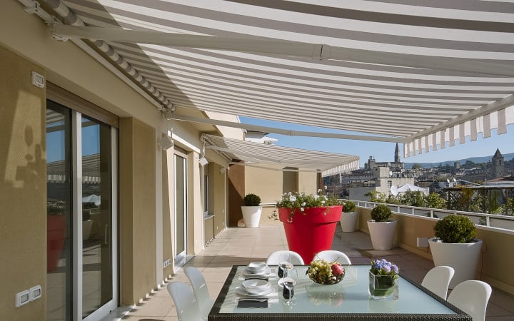 Store banne couvrant une terrasse et fixé sur un mur avec isolation extérieure